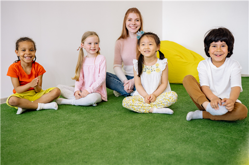 Kids seating inside classroom with teacher in a row.